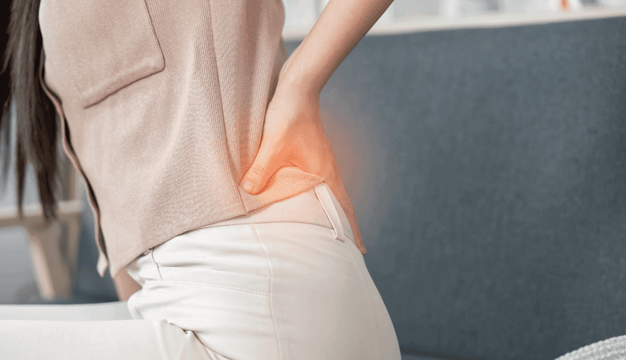 Person hält sich den Rücken vor Schmerzen